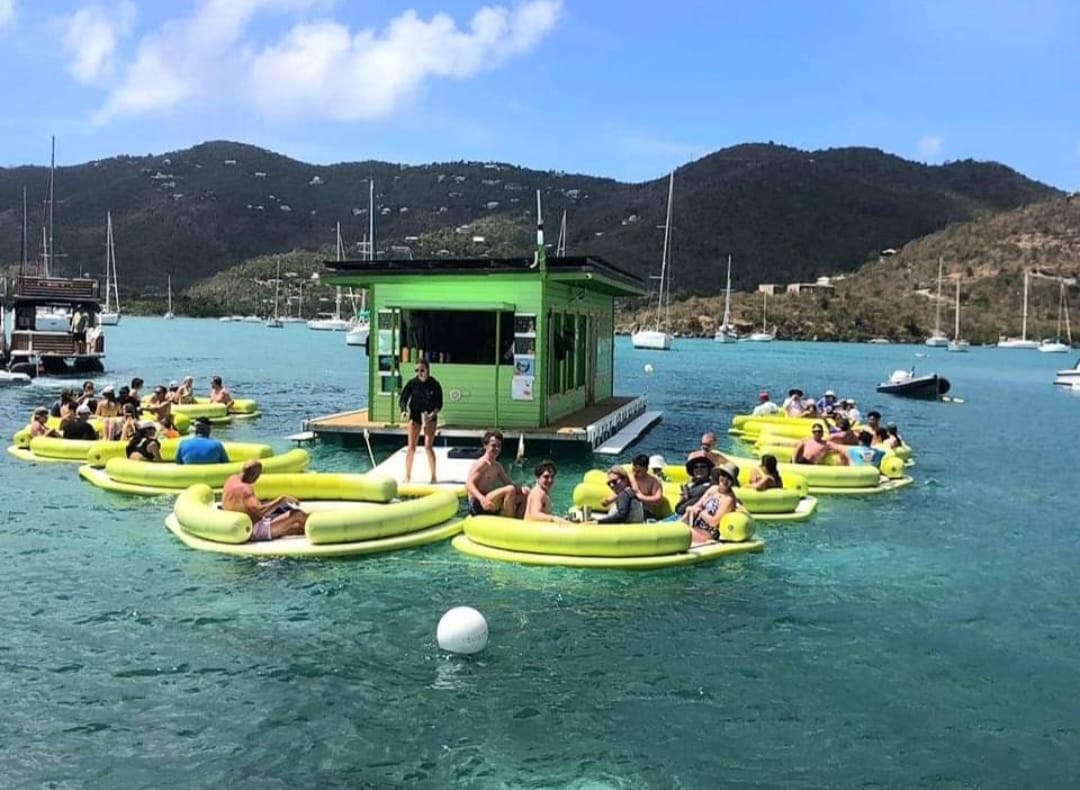 People socializing in water at floating bar